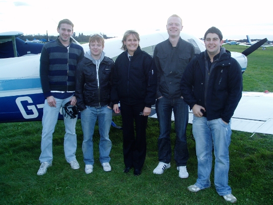 Five people standing in front of an aircraft - photograph